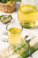 Cup with green tea with flower and green leaves.