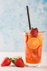 Classic fresh Strawberry lemonade with lime slices in a glass.