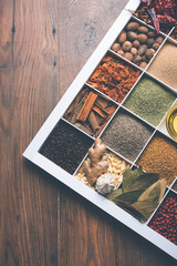 Indian Spices in white wooden box with cells, selective focus.