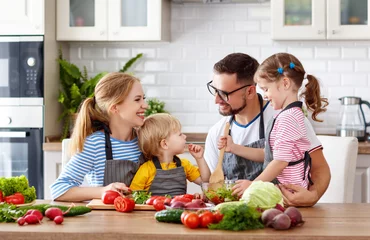 Crédence de cuisine en verre imprimé Cuisinier famille heureuse avec enfants préparant une salade de légumes.