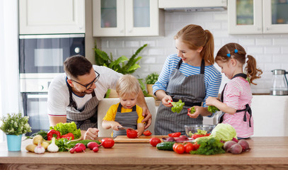 happy family with children preparing vegetable salad .