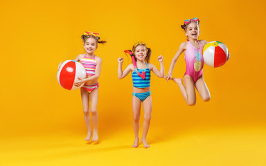 funny funny happy children in bathing suits  jumping  on colored background