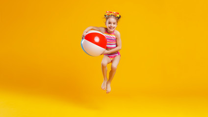 funny happy child  jumping in swimsuit    on colored background