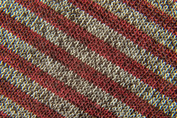 background of a fabric of red-gray striped weaving     close-up