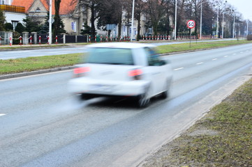 Rozmyta sylwetka samochodu w ruchu na ulicy w mieście. - obrazy, fototapety, plakaty