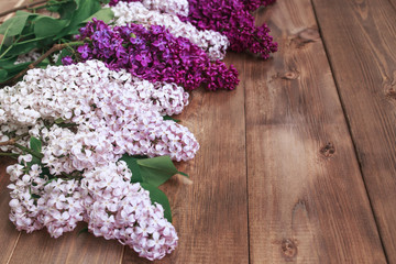 Bouquet of purple lilacs flowers on a brown wooden background