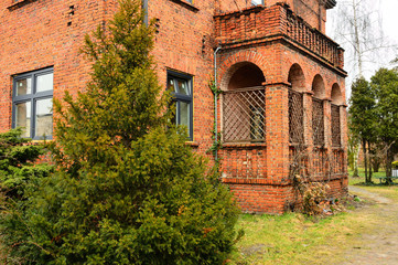 Dom z czerwonej cegły i ganek przed trawnikiem. - obrazy, fototapety, plakaty