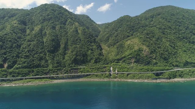Aerial view of Patapat viaduct in the coast of Pagudpud, Ilocos Norte. Highway with bridge by coast sea near the mountains. Philippines, Luzon. Highway along the coast.