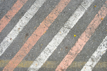 white and red diagonal line on the old and dirty concrete street surface, concrete road. background texture