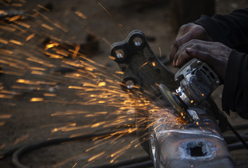  Man grinds a steel piece