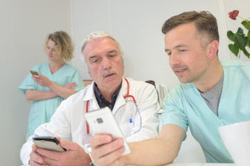 doctor showing mobil phone to doctor