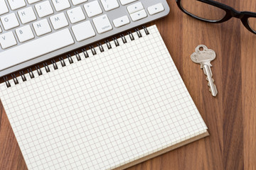 Blank notebook with computer and key