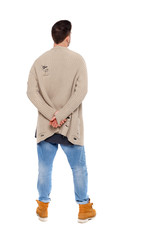 Back view of a stylish man in a knitted sweater.