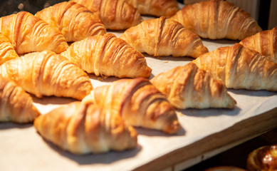 Croissants in a bakery shop. freshly baked croissants on texture background.