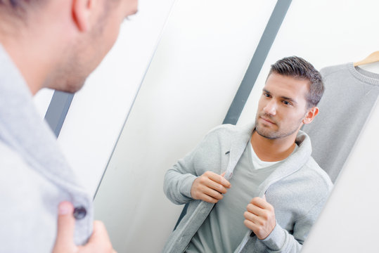 Man trying on jacket in fitting room