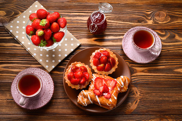 Fototapeta na wymiar Tea drinking with tartlets and cakes with strawberries