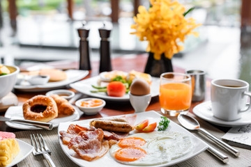 Setting of breakfast includes coffee, fresh orange juice, eggs on table in hotel restaurant - obrazy, fototapety, plakaty