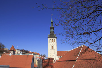 Beautiful view of the maiden's tower with the adjacent fortress wall and the dome of the tower Oleviste Churchand in Tallinn, Estonia on a sunny day