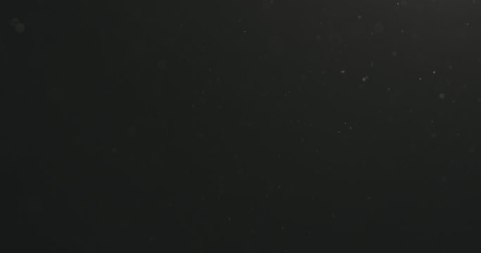dust particles floating over black background with motion blur