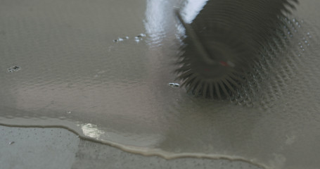 closeup using spike roller to remove air bubbles from self leveling floor