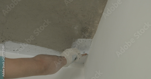 Worker Painting Concrete Ceiling Into White With Brush Stock