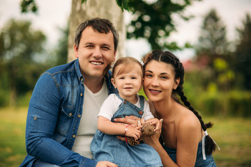 Fototapeta premium Happy male and female playing with child outside