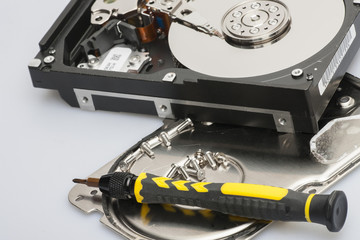 The disassembled hard drive next to the tools with which it was disassembled The concept of data protection Allegory