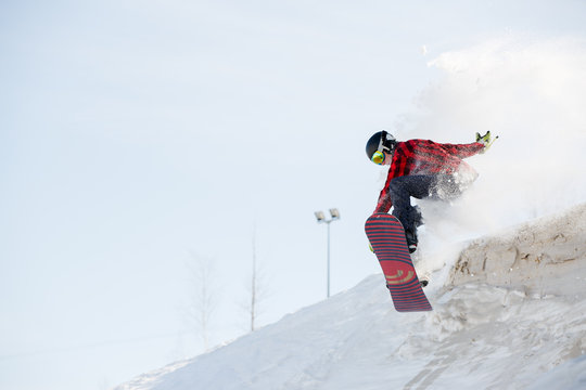 Image of man with snowboard jumping from mountain slope