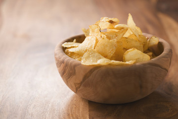 organic potato chips with herbs in bowl on wood table