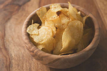 organic potato chips with herbs in bowl on wood table