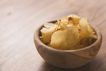 organic potato chips with herbs in bowl on wood table