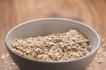 closeup oat flakes in white bowl with shallow focus