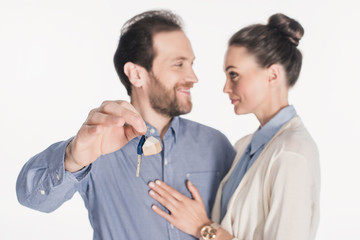 portrait of smiling couple with key from new house isolated on white