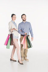 cheerful couple with shopping bags isolated on white