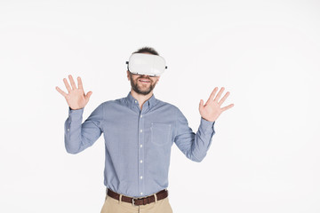 portrait of smiling man in virtual reality headset with outstretched arms isolated on white