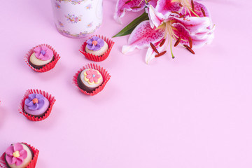 A bouquet of lily flowers, on a pink background, a cup of morning coffee and coffee pots. Free space for text. Flat lay, copy space,