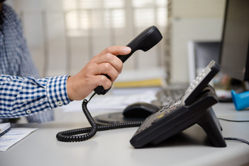 Closeup on busy office phone workplace, light table window. Modern administration control lcd display support solution response. Digital connection device communication landline equipment technology