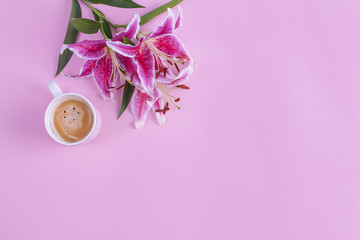 Pink background, cup of morning coffee and a bouquet of flowers of lilies. Free space for text. Flat lay, Copy space.