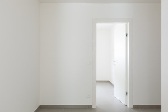 Detail of open doors in all-white apartment