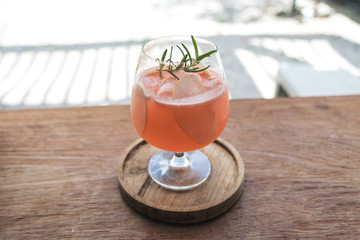 Closeup image of a glass of litchi fruit juice on wooden saucer and table in cafe