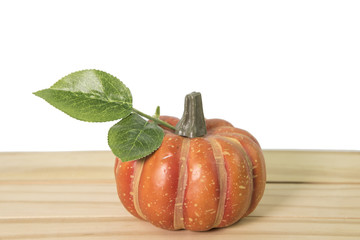 Artificial pumpkin on wooden floor