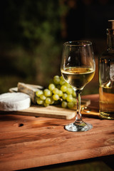 romantic dinner with a glass of wine and snacks on an old wooden table on a summer evening