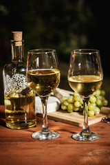 romantic dinner with two glasses of wine and snacks on an old wooden table on a summer evening