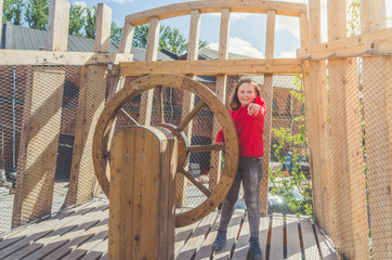 girl on a wooden Playground in the form of a pirate ship