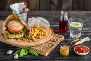 Tasty hamburger with meat and vegetables against a dark background. Fast food. It can be used as a background
