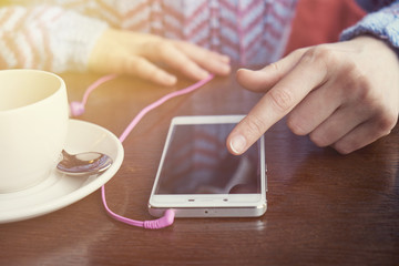 teenager girl hands with smart phone, headphones and cup of coffee. For Graphic display montage.