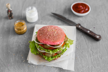 Tasty hamburger with meat and vegetables against a dark background. Fast food. It can be used as a background