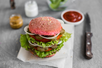 Tasty hamburger with meat and vegetables against a dark background. Fast food. It can be used as a background