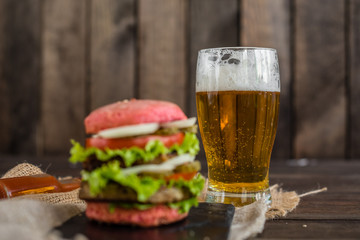 Tasty hamburger with meat and vegetables against a dark background. Fast food. It can be used as a background