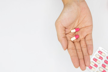 pink pills in hand on white background, Taking Your Medication.